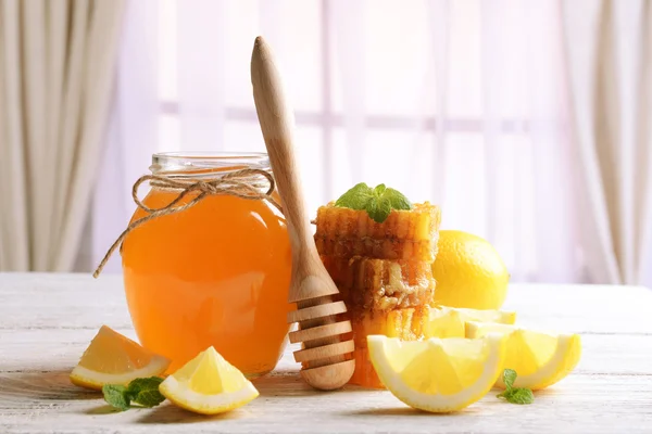 Délicieux miel avec citron sur la table sur fond clair — Photo