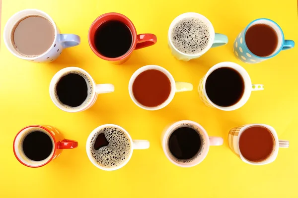 Veel kopjes koffie op kleurentabel, bovenaanzicht — Stockfoto