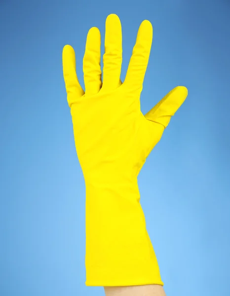 Rubber glove on hand, on blue background — Stock Photo, Image