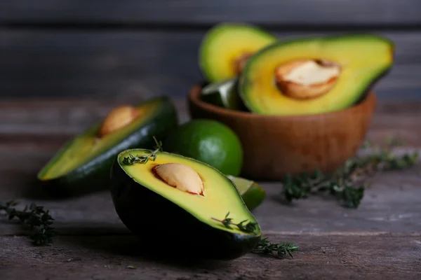 Aguacate en rodajas con hierba en tazón sobre fondo de madera —  Fotos de Stock