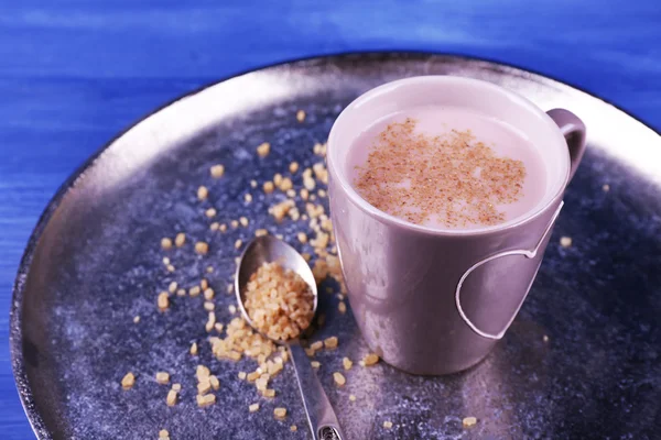 Чашка какао с ложкой сахара на металлическом подносе на цветном деревянном фоне — стоковое фото