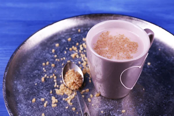 Cup of cocoa with spoon of sugar on metal tray on color wooden background — Stock Photo, Image