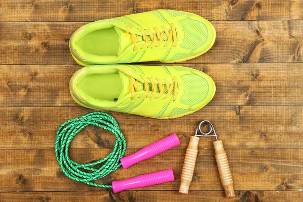 Schuhe und Sportgeräte auf Holzboden, Draufsicht — Stockfoto