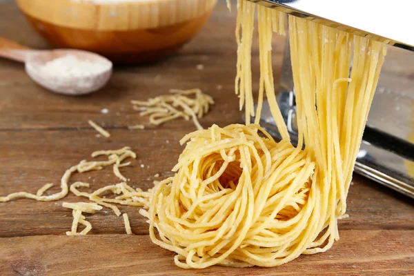 Hacer vermicelli con máquina de pasta sobre fondo de madera — Foto de Stock