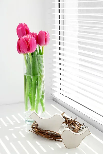 Rosa hermosos tulipanes en el alféizar de la ventana con luz solar — Foto de Stock