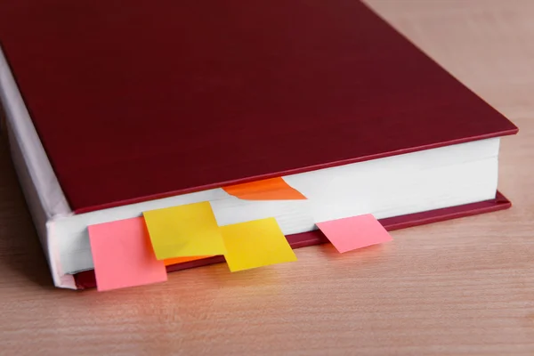 Boek met bladwijzers op houten tafel — Stockfoto