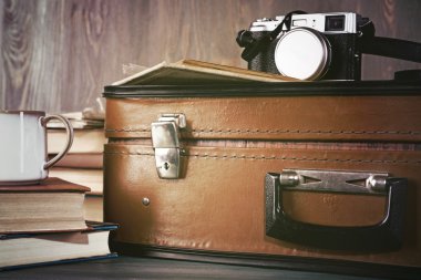 Kitap ve ahşap arka plan üzerinde kamera ile Vintage çanta