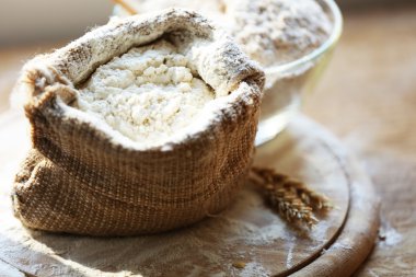 Çuval bezi çanta ile kesme tahtası ahşap zemin üzerine un