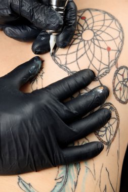 Dövme, yakın çekim yapma işlemi gösteren tattooer