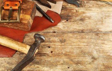Ahşap arka plan üzerinde deri ve el sanatları araçları