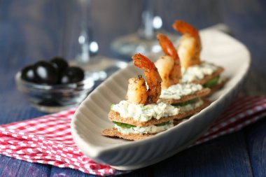 Masada karides ve salatalık tabağı olan aperatif kanepe.