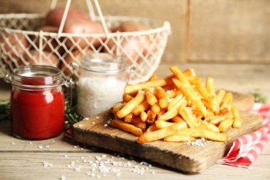 Tahtada patates kızartması, ahşap masa arkasında.