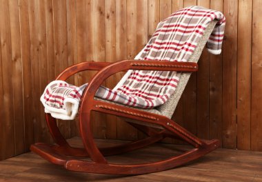 Sallanan sandalye ahşap duvar arka plan üzerinde ekose kaplı