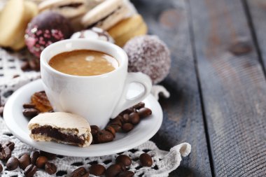 Yumuşak renkli kurabiye ve kahve kupa ahşap masa arka plan üzerinde