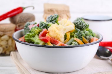 Peçete, ahşap masa arka plan üzerinde kase sebze dondurulmuş