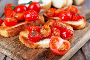 Beyaz dilim tost ekmeği kesme tahtası üzerinde ahşap masa, closeup konserve domates ile