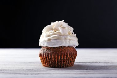 Lezzetli Hindistan cevizi kek krem rengi ahşap masa ve koyu arka plan