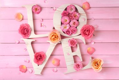 Güzel gül pembe ahşap plakalar arka plan üzerinde kelime aşk ile