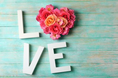 Renk ahşap plakalar arka plan üzerinde kelime aşk ile güzel güller
