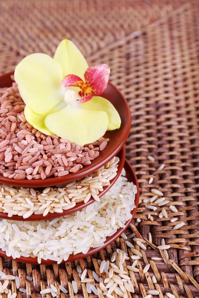 Diferentes tipos de arroz em tigelas no fundo de vime — Fotografia de Stock