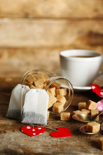 Etiqueta de té en forma de corazón y taza de té con sobre fondo de madera — Foto de Stock