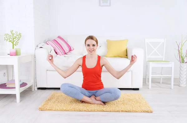 Giovane donna che fa yoga a casa — Foto Stock