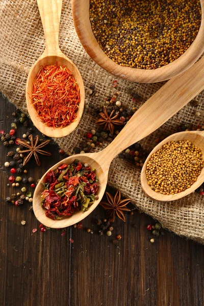 Different kinds of spices on wooden background — Stock Photo, Image