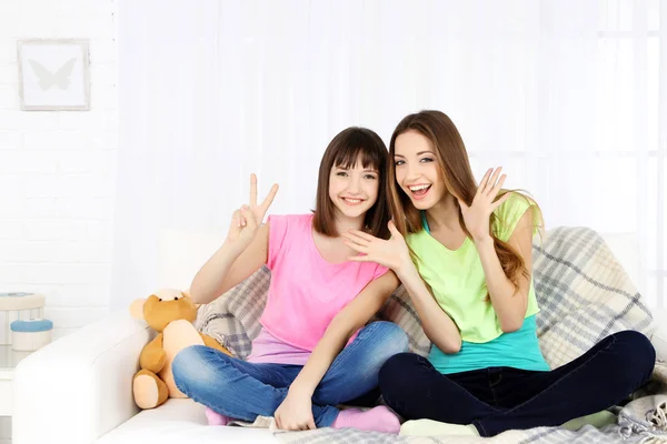 Dos chicas sonriendo en el fondo interior de casa —  Fotos de Stock