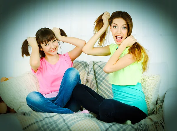 Dos chicas sonriendo en el fondo interior de casa — Foto de Stock