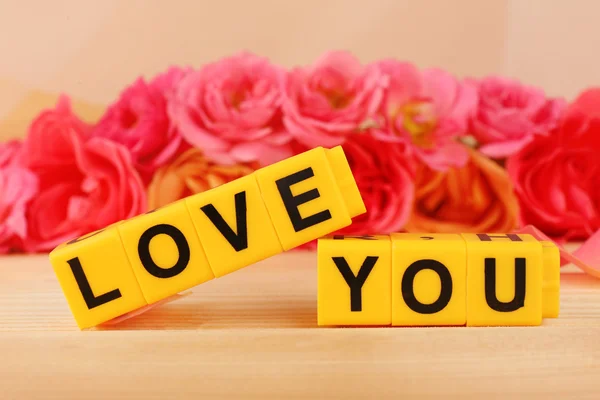 Words Love You formed from cubes with flowers on bright background — Stock Photo, Image