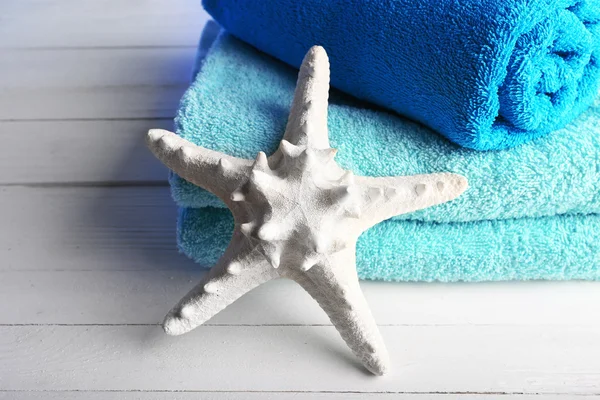 毛巾与木桌背景上的海星 — 图库照片