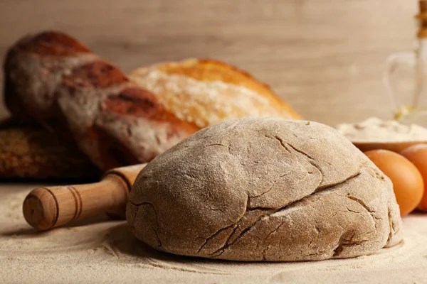 Brood op tafel en houten achtergrond maken — Stockfoto