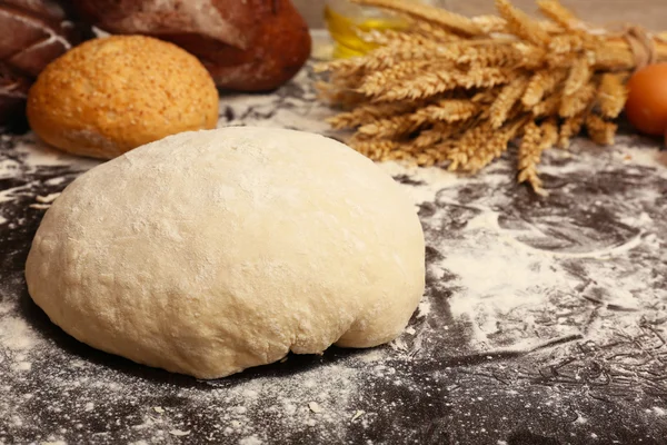 Fazendo pão na mesa no fundo de madeira — Fotografia de Stock