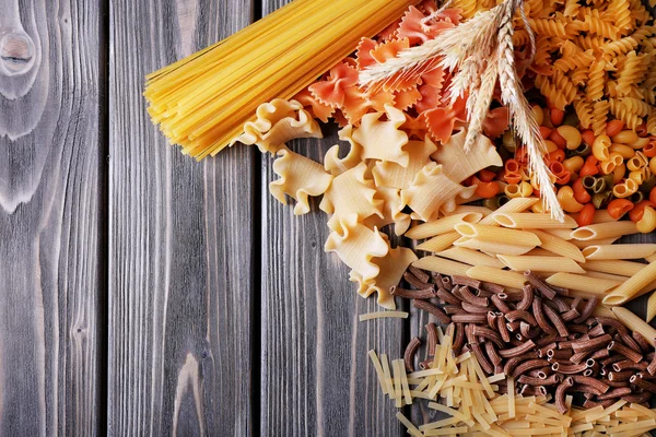 Diversi tipi di pasta su tavole di legno sfondo — Foto Stock