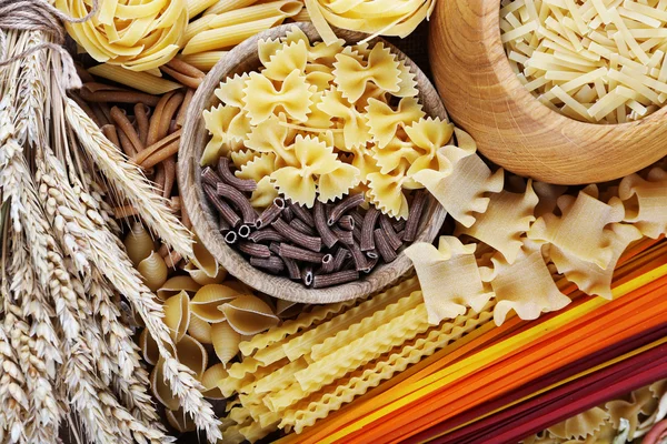 Verschillende soorten pasta met houten gebruiksvoorwerp, macro weergave — Stockfoto