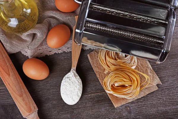 Pasta mit der Nudelmaschine auf rustikalem Holzgrund zubereiten — Stockfoto