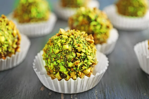 Tasty homemade pistachio candies on wooden table
