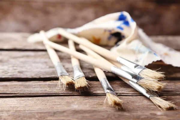 Paint brushes on old wooden background — Stock Photo, Image