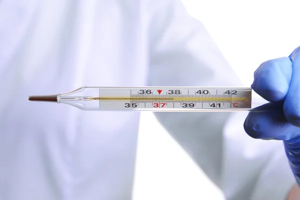 Médico segurando termômetro de perto — Fotografia de Stock