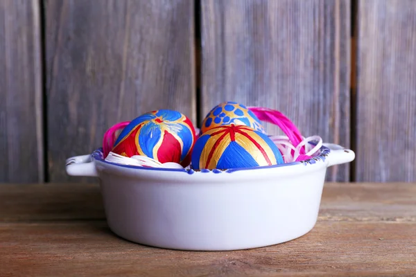 Velikonoční vejce v míse na dřevěné pozadí — Stock fotografie