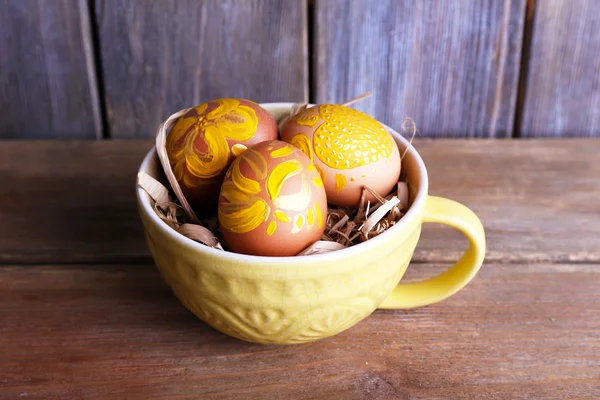 Easter eggs in mug on wooden background — Stock Photo, Image