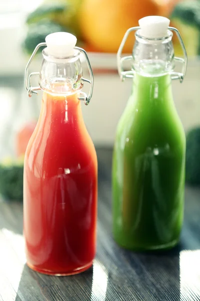 Bottiglie di succo con frutta e verdura in cassa sul tavolo da vicino — Foto Stock