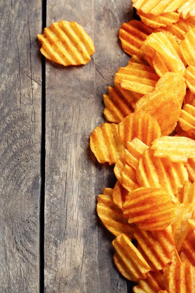 Delicious potato chips on wooden table close-up — Stock Photo, Image