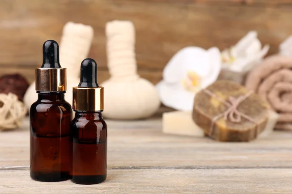 Beautiful spa composition with aromatic oil and massage bags on wooden background — Stock Photo, Image