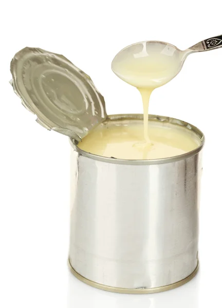 Tin can of condensed milk with spoon isolated on white — Stock Photo, Image