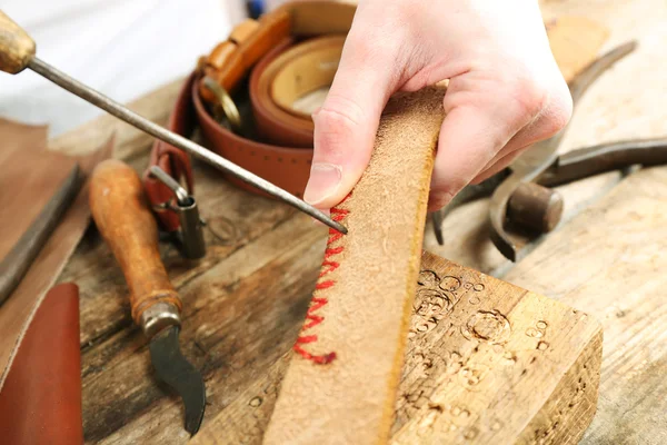 Repairing leather belt in workshop — Stock Photo, Image