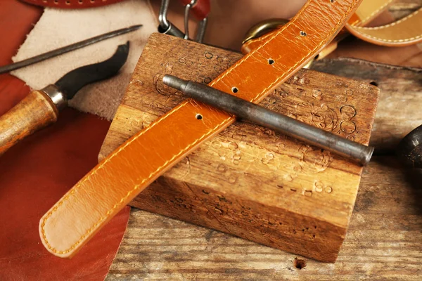 Craft tools with leather belt on table close up — Stock Photo, Image