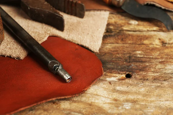 Kůže a řemeslné nástroje na stole zblízka — Stock fotografie