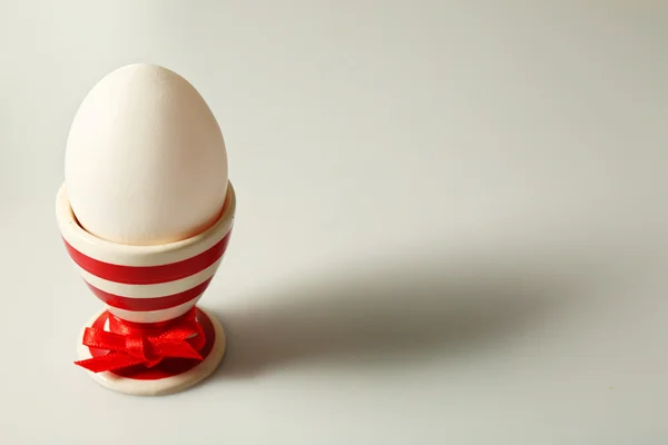 Boiled egg in holder on light background — Stock Photo, Image