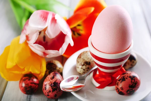 Easter egg in houder en tulp bloemen op houten achtergrond — Stockfoto